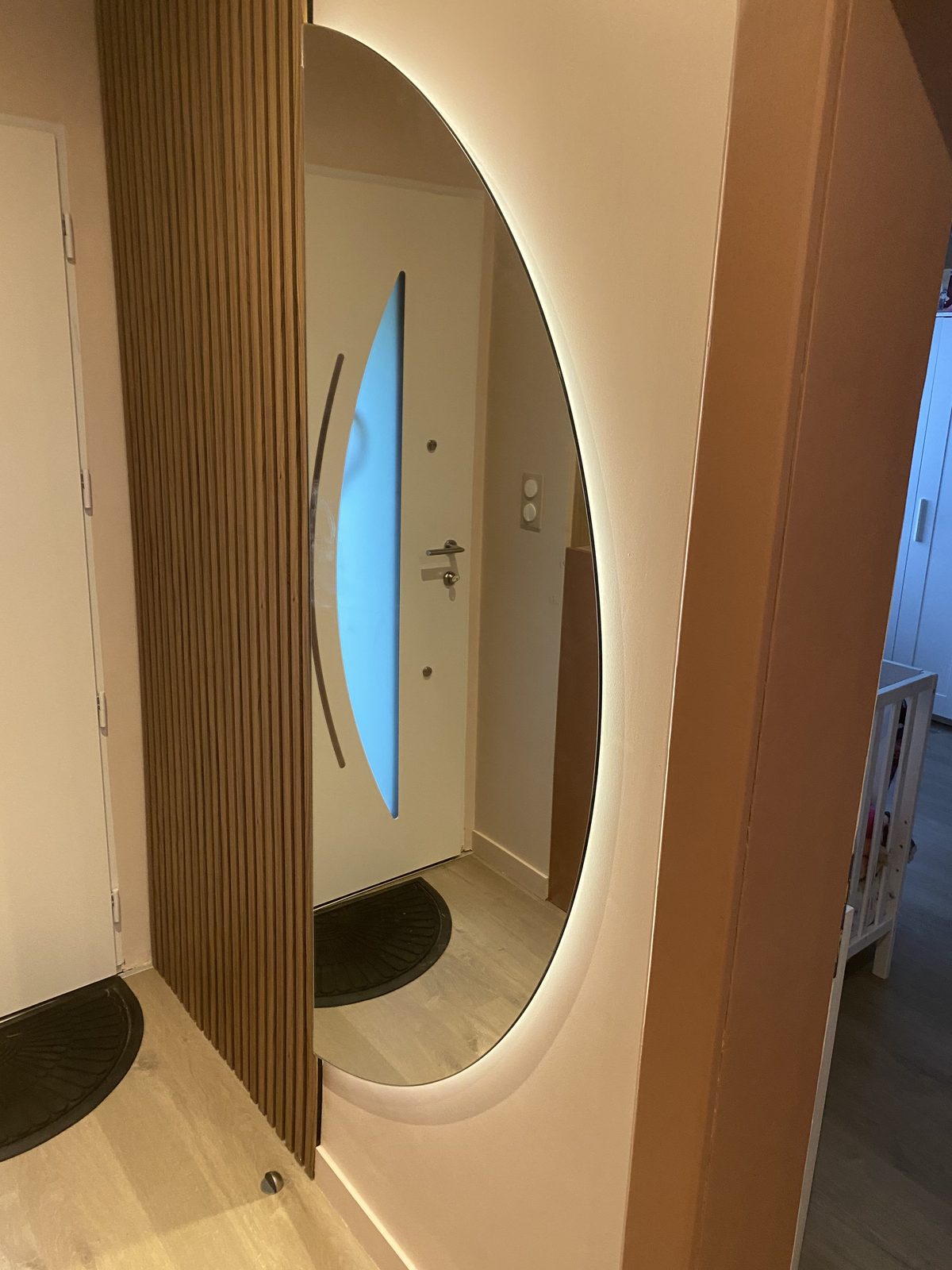 Miroir ovale sur-mesure rétroéclairé dans une entrée — réalisation CM Déco
